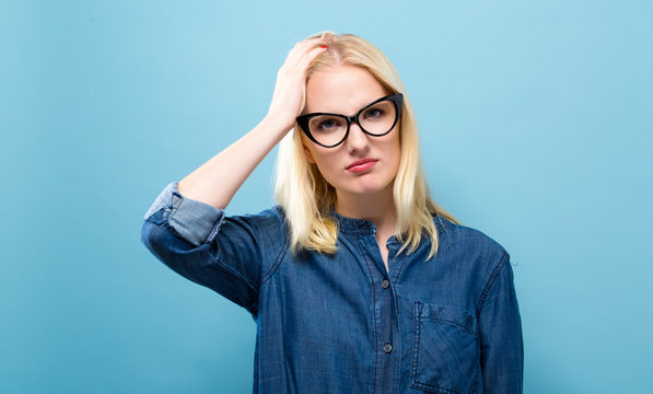Young woman feeling stressed on a solid background
