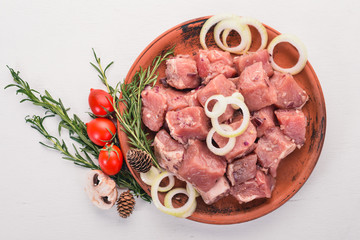 Raw uncooked meat sliced in cubes on wooden rustic background, top view.