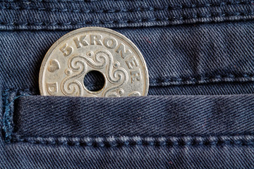 Denmark coin denomination is 5 krone (crown) in the pocket of dark blue denim jeans