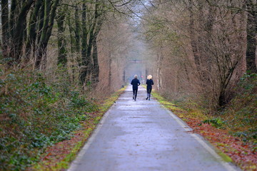 Family couple in a morning forest jogging.