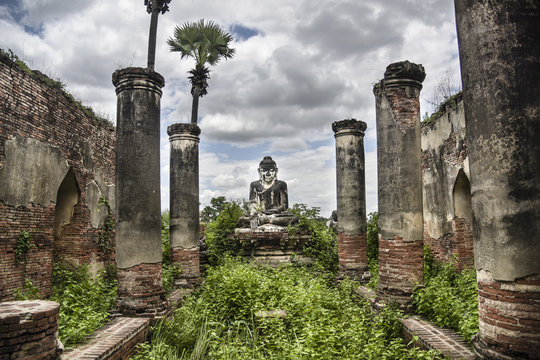 Buddha statue at Inwa against cloudy sky