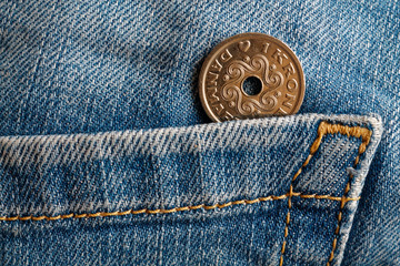 Denmark coin denomination is 1 krone (crown) in the pocket of old blue worn denim jeans