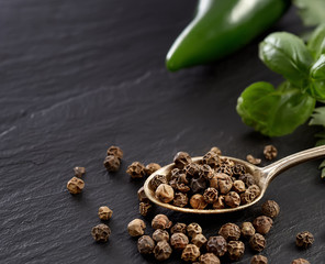 black pepper peas  in a spoon on a black background