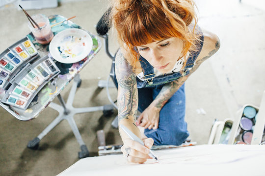 High angle view of artist drawing sketch on canvas in studio