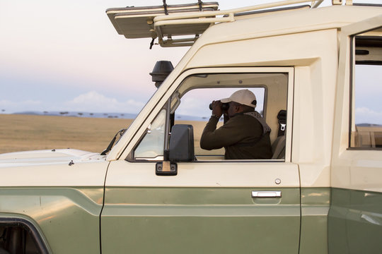 Man looking through binoculars while sitting in van