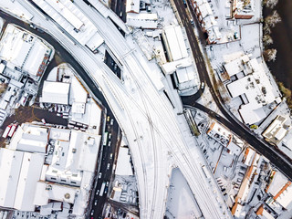 Aerial view of snow covered rail and road networks. Snow, ice and winter weather conditions close railway links and shut roads causing transport delays and dangerous conditions.