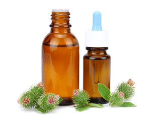 bottle with burdock (castor, agrimony) oil isolated on white background