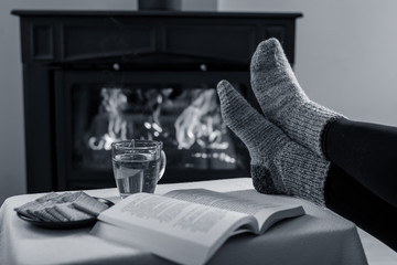 Women's legs in socks in front of the fireplace