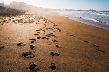 Scenic view of a beach and foot prints on the sand