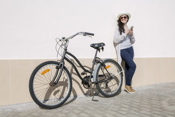 Fototapeta na wymiar Smiley female with device and bicycle