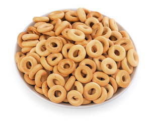 Ring-shaped cracknels (sooshkas), little bagels, in ceramic a plate. Isolated on a white background, close-up, top view.