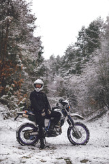 Fototapeta na wymiar Rider man on a motorcycle Winter motocross. Skid on a snowy forest. the snow from under the wheels of a motorcycle Enduro. off road dual sport travel tour, active life style concept vertical