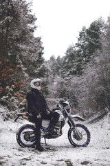 Fototapeta na wymiar Rider man on a motorcycle Winter motocross. Skid on a snowy forest. the snow from under the wheels of a motorcycle Enduro. off road dual sport travel tour, active life style concept vertical