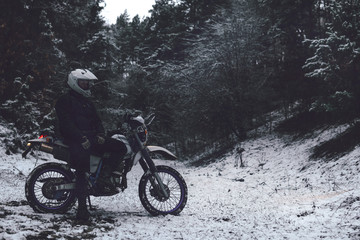 Rider man on a motorcycle Winter motocross. Skid on a snowy forest. the snow from under the wheels of a motorcycle Enduro. off road dual sport travel tour, active life style concept