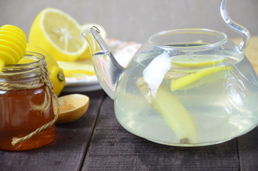 Cup of ginger tea with honey and lemon on wooden table