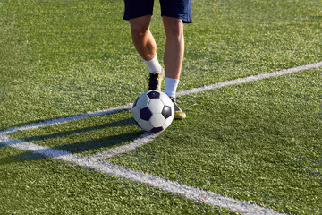 Footballer is preparing to strike a corner kick on the goal.