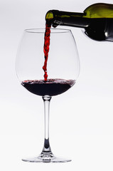 Pouring from wine bottle into an elegant crystal glass