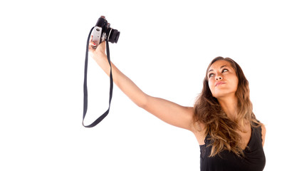 Pretty happy girl taking a selfie with a vintage camera; isolated on white, customizable background with copy space