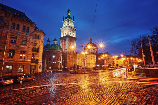 Scenic view on illuminated Assumption Church Bell Tower at twilight with vintage tram on foreground, Lviv, Ukraine.
