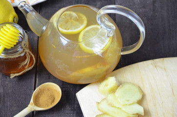Cup of ginger tea with honey and lemon on wooden table