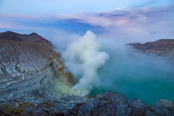 Fototapeta premium Sunrise at Kawah Ijen volcano crater with sulfur fume. Ijen crater the famous tourist attraction near Banyuwangi, East Java, Indonesia