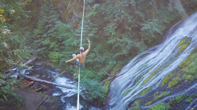 Fit Man Highlining Over A Waterfall In Oregon
