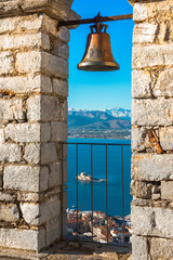 Obraz premium Old town of Nafplion in Greece view from bell tower, with tiled roofs, small port and bourtzi castle on the Mediterranean sea water