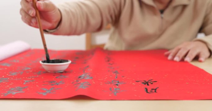 Asian man writing chinese calligraphy