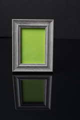 Vintage gray wooden frame on black with reflection
