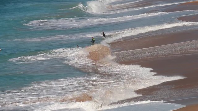 Guys surfing on El Palmar beach, on the coast of Cadiz, Andalusia, Spain