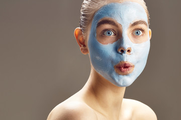 Spa Woman applying mask for face and is surprised