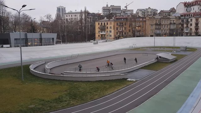 Two teenage teams playing cycle polo outdoors, hardcourt bike polo game