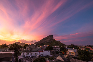 Obraz premium Summer sunset with pink and orange colors and houses in the foreground 