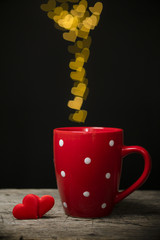 Valentine's day concept with hearts and cup over black background. © PAstudio