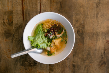noodle in the bowl with meat and vegetable lemon as Tom Yam dry and soup on table background