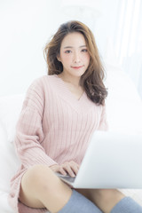 Naklejka premium Attractive female using laptop at bedroom. People lifestyle concept.