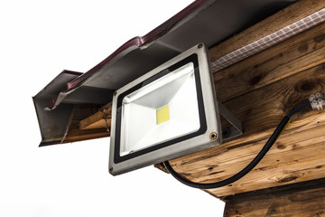 Garden LED spotlight on a wooden building close-up.