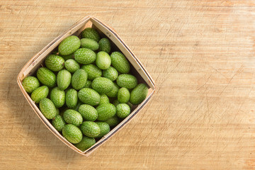 cucamelons in container on wood background