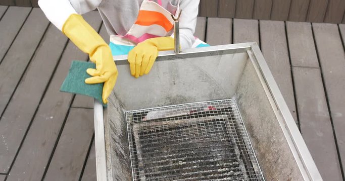 Woman cleaning barbecue oven with Scour Pad