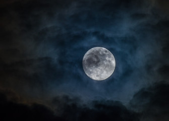 Fototapeta na wymiar Super full Moon shining through dark clouds
