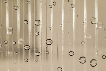 Water drop close-up on the plastic transparent surface rough striped, abstract background