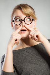 Girl pinches her nose because of stench stink.