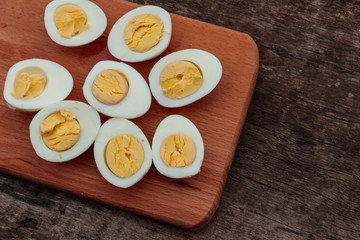 Boiled eggs on cutting board on wooden table