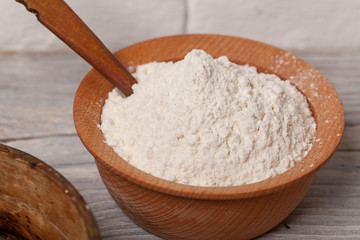 Fototapeta na wymiar Wheat flour in wooden bowl