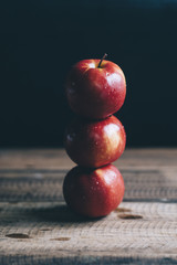 red apple stacked on a wooden table