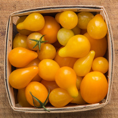 Farmers market wood pint container of yellow tomatoes 