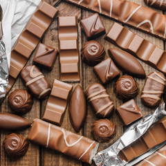 Background of chocolates, bars and sweets, free space for text, close up