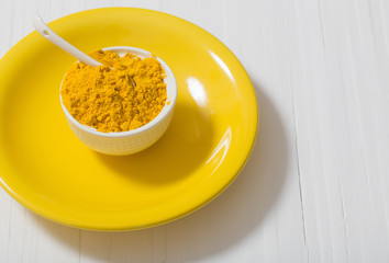 turmeric on yellow plate on white table