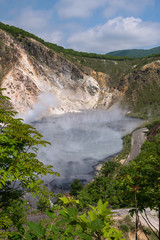 Fototapeta na wymiar The hot water of Oyunuma pond in the volcanic landscape of Hell Valley (Jigokudani), Noboribetsu, Hokkaido, Japan