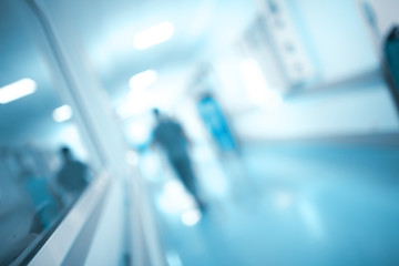 Obscure figure walking through the hospital corridor, unfocused background